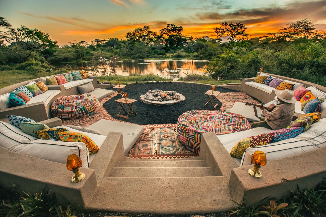 The sunken fire-pit boma at Finch Hattons at sunset, with the springs behind.