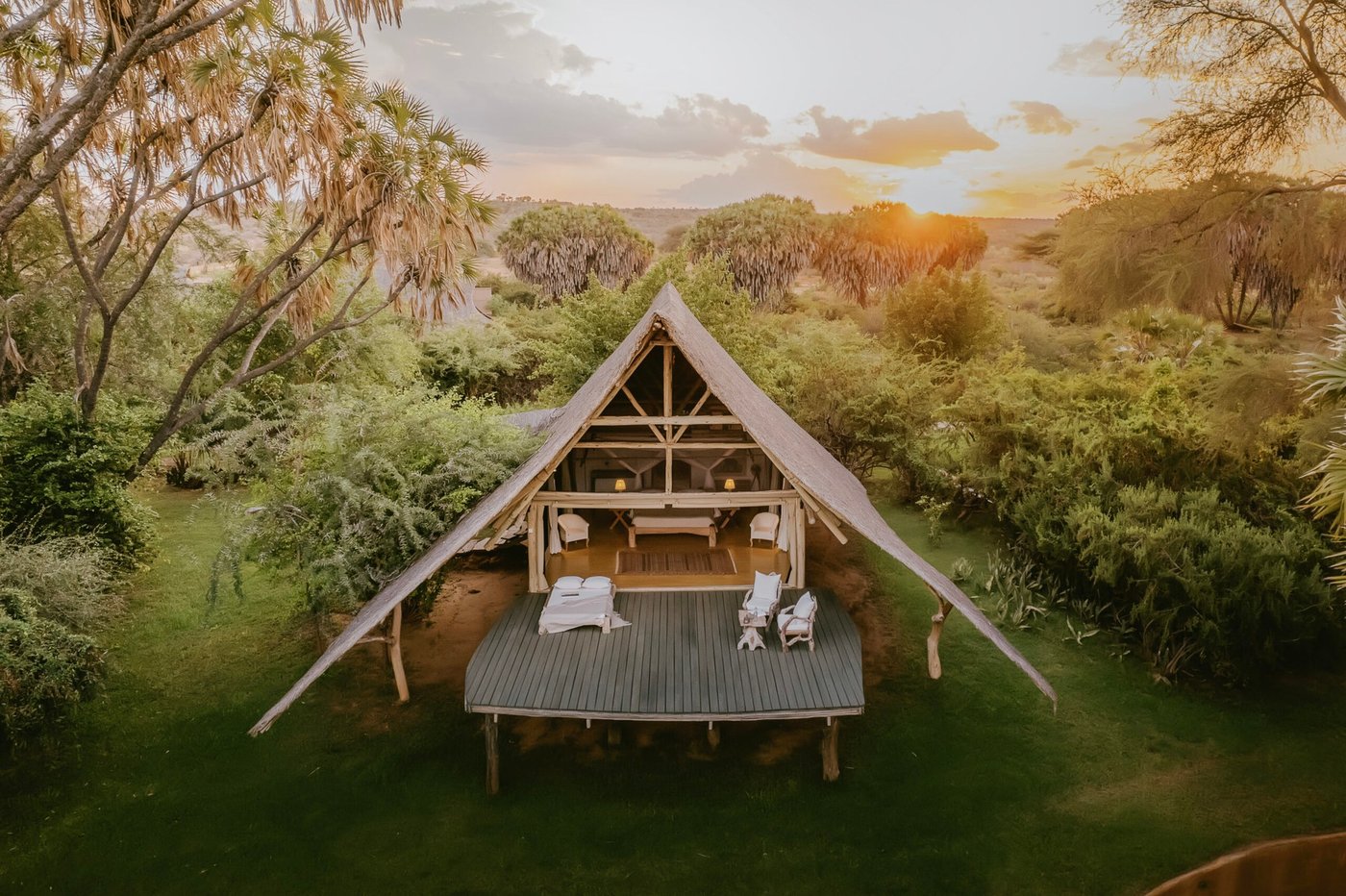 A-frame thatched tent at sunset among doum palms at Galdessa Camp in Tsavo