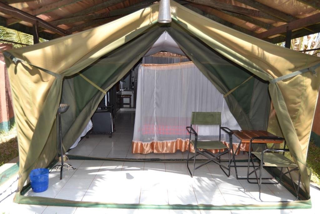 Mosquito netting and camp chairs furnish a canvas tent at Impala Safari Lodge