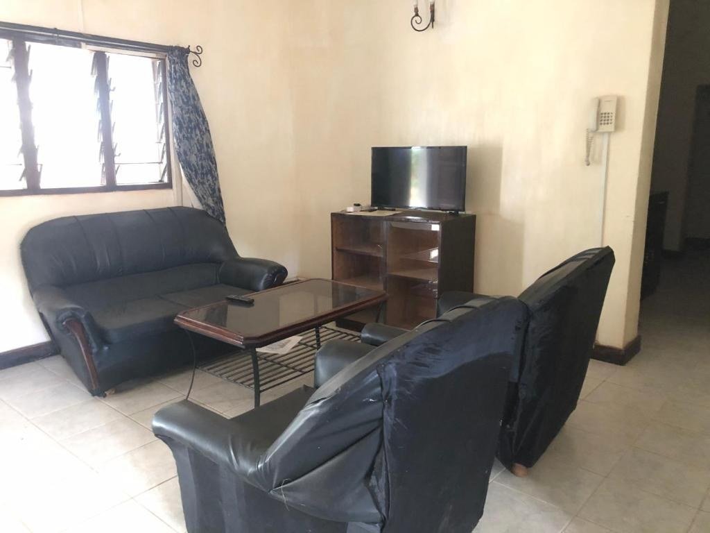 Black leather sofas furnish a simple lounge at Impala Safari Lodge