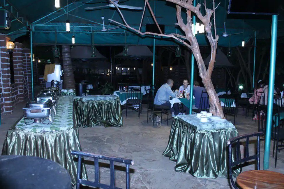Guests dine by lantern light on the terrace at Impala Safari Lodge