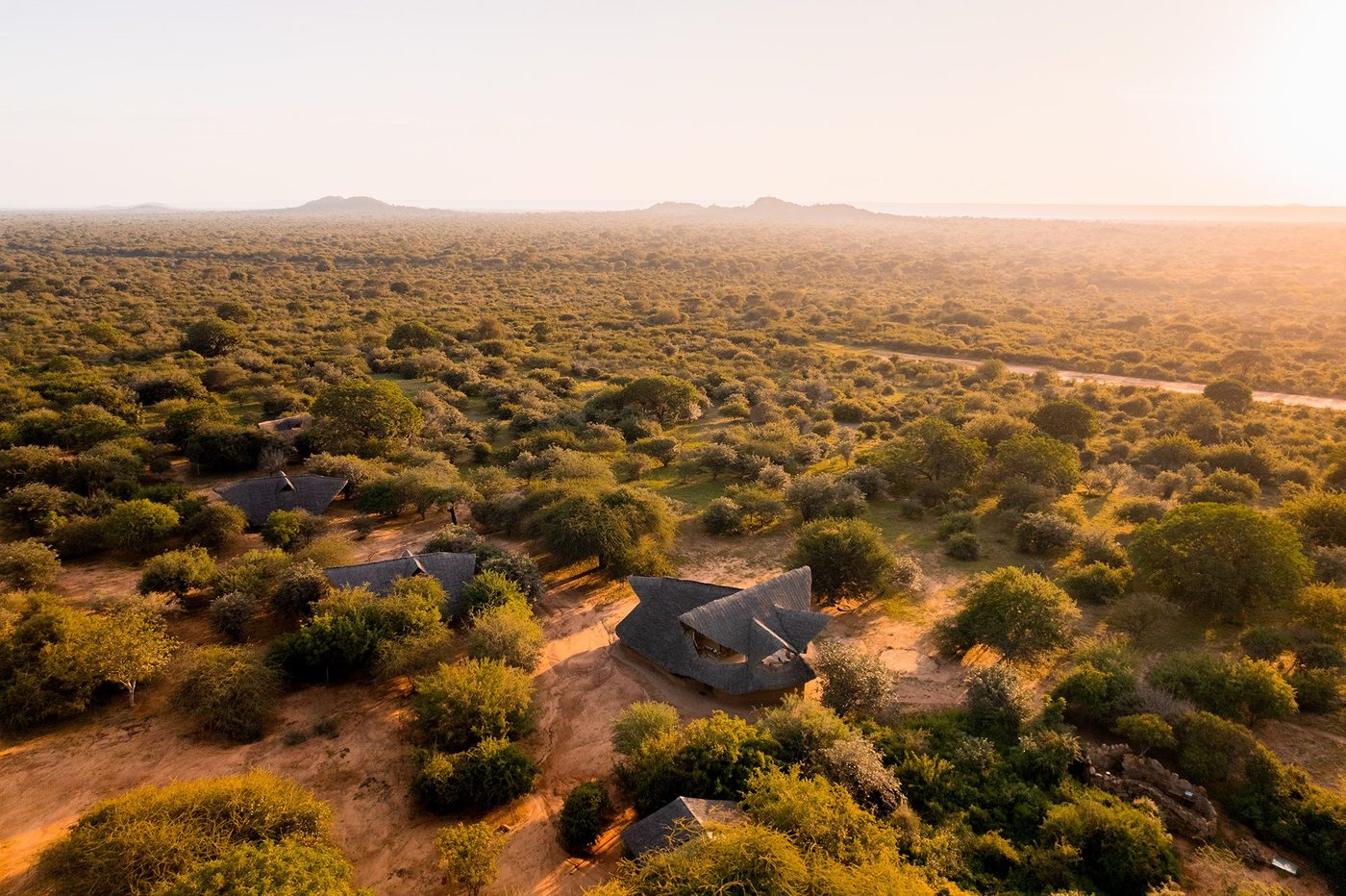 Aerial view at sunrise shows tents scattered through scrubland at Ithumba Camp in Tsavo