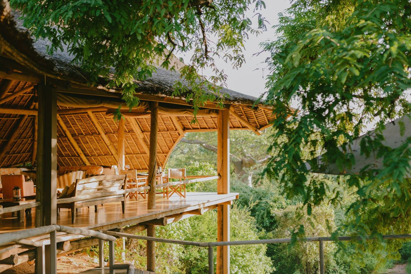 A thatched dining deck extends into the treetops above the bush at Ithumba Hill in Tsavo