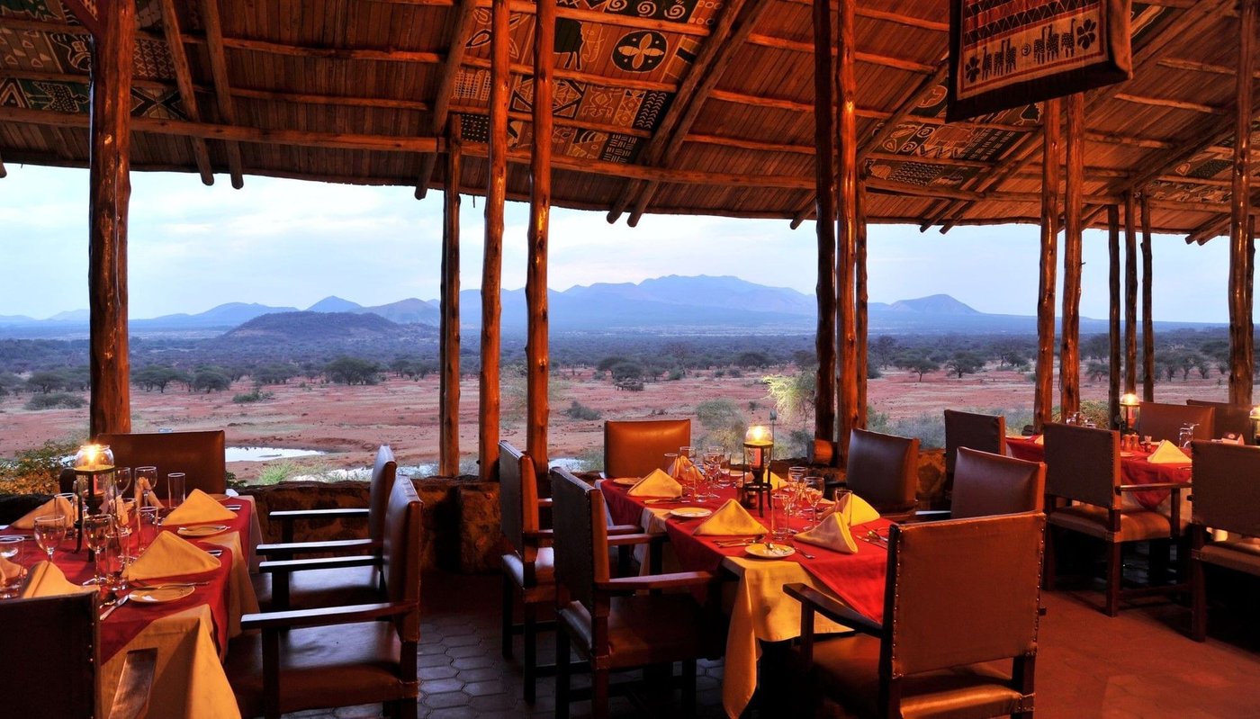 Dining tables with red cloths beneath the thatched roof at Kilaguni Serena Safari Lodge