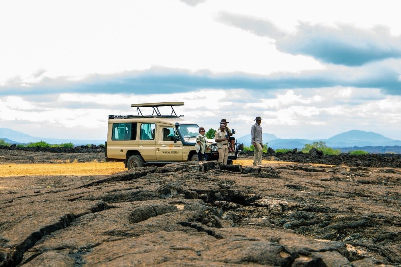 Safari vehicle and guides crossing the black Shetani lava field near Kilaguni Serena Safari Lodge