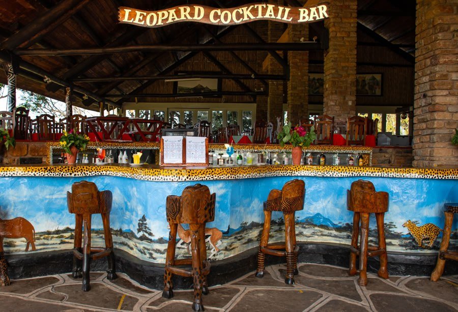 Zebra-print stools line the painted Leopard Cocktail Bar at Ngulia Safari Lodge
