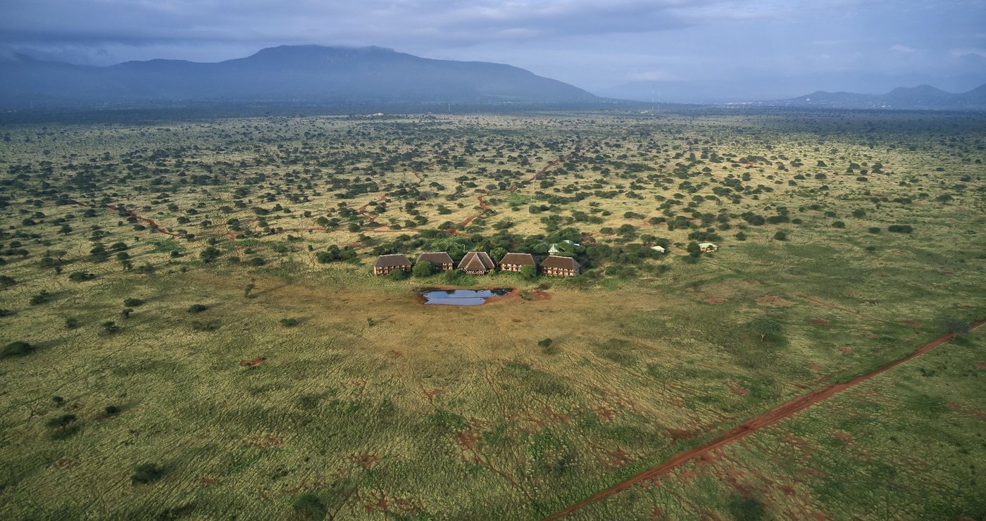 Aerial view of the lodge's thatched roofs scattered across green bushland at Ngutuni Safari Lodge