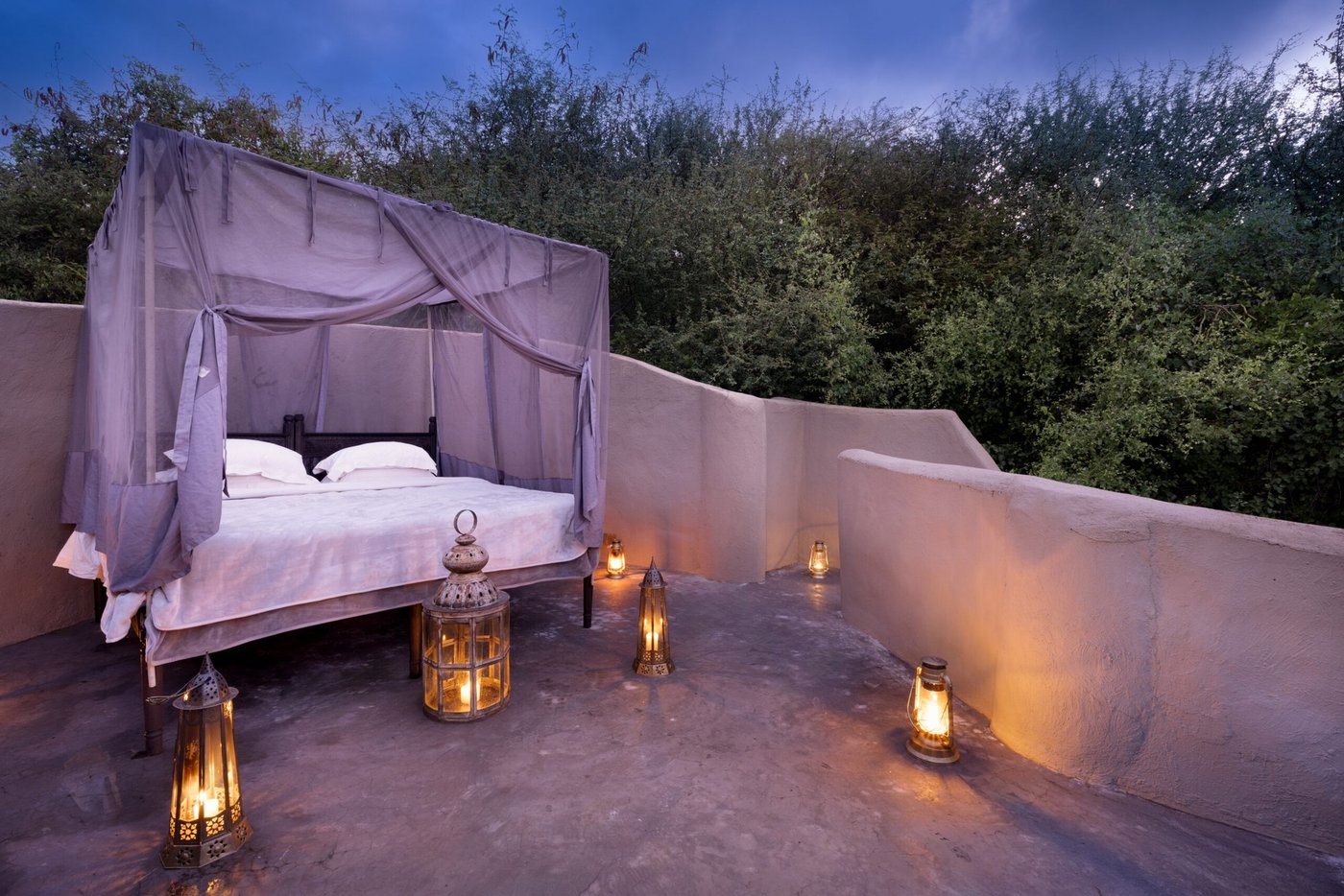 Four-poster rooftop star bed lit by lanterns at ol Donyo Lodge