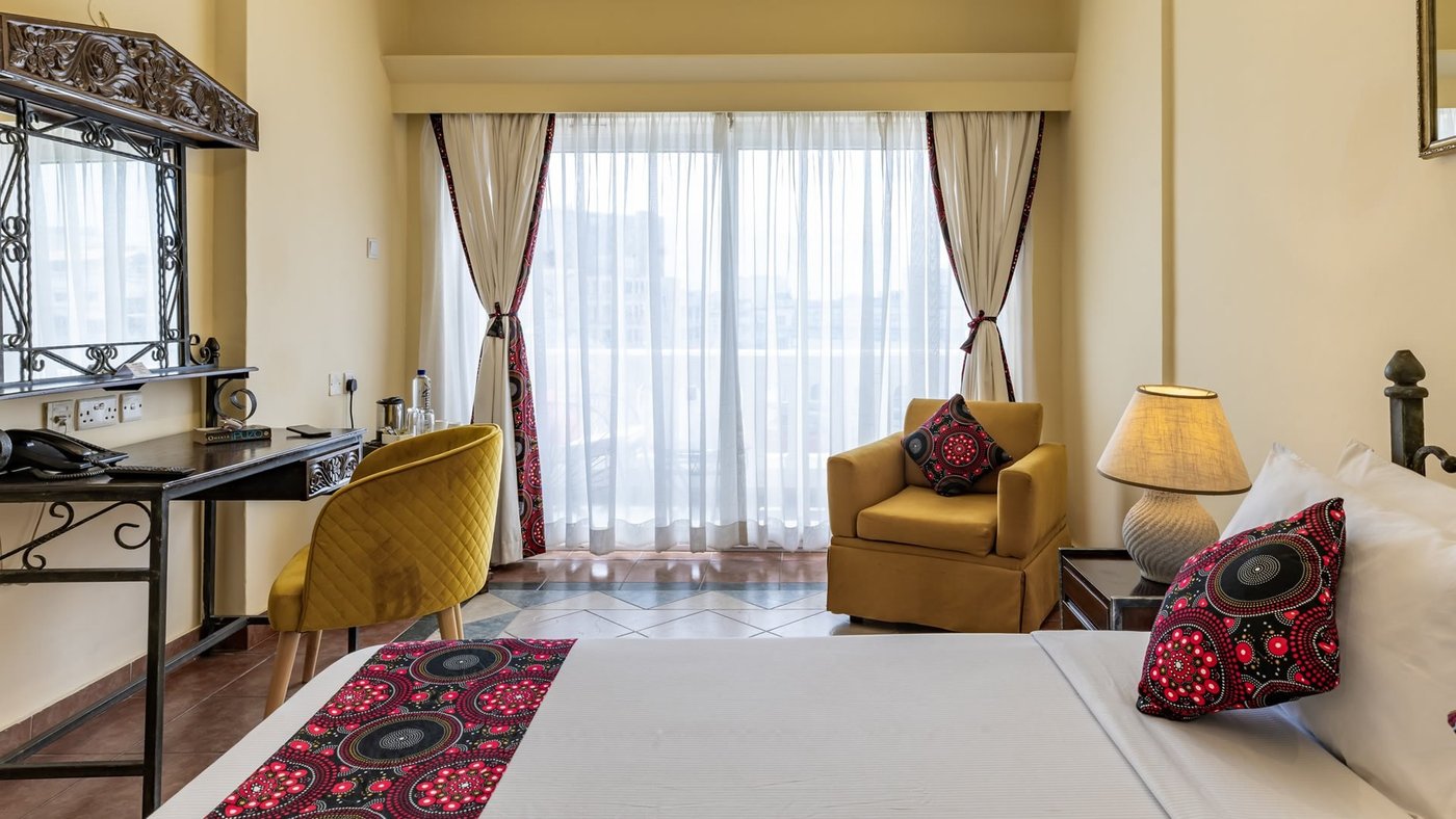 A yellow armchair and patterned pillows furnish a tent lounge at Sentrim Tsavo East Camp