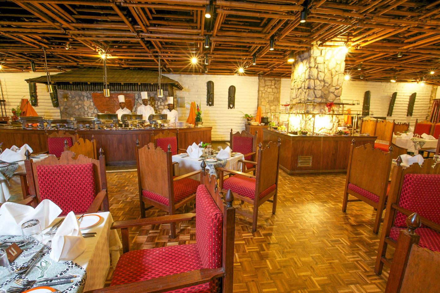 Dining hall with red chairs and carved wooden tables at Taita Hills Safari Resort & Spa