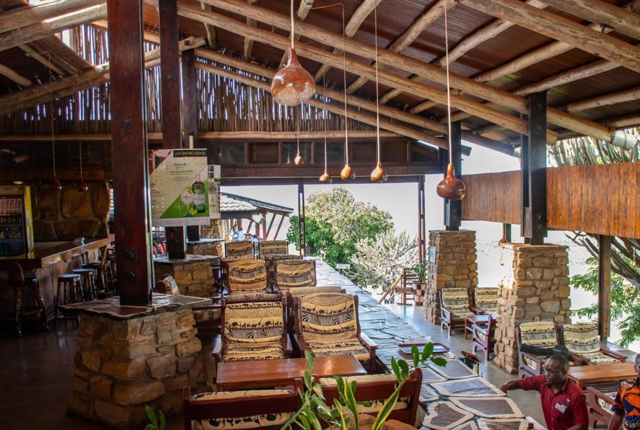 Carved gourd lamps hang above zebra-print chairs in the lounge at Voi Safari Lodge