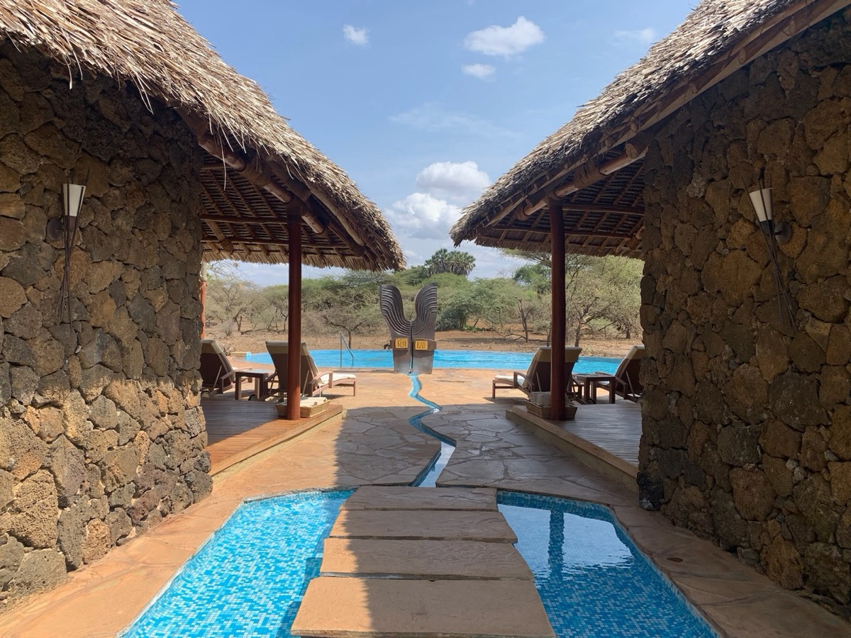 The pool sits between two of the stone and thatch bandas, with nothing between it and the bush beyond. Severin is unfenced, which is why someone walks you back to your tent after dark.